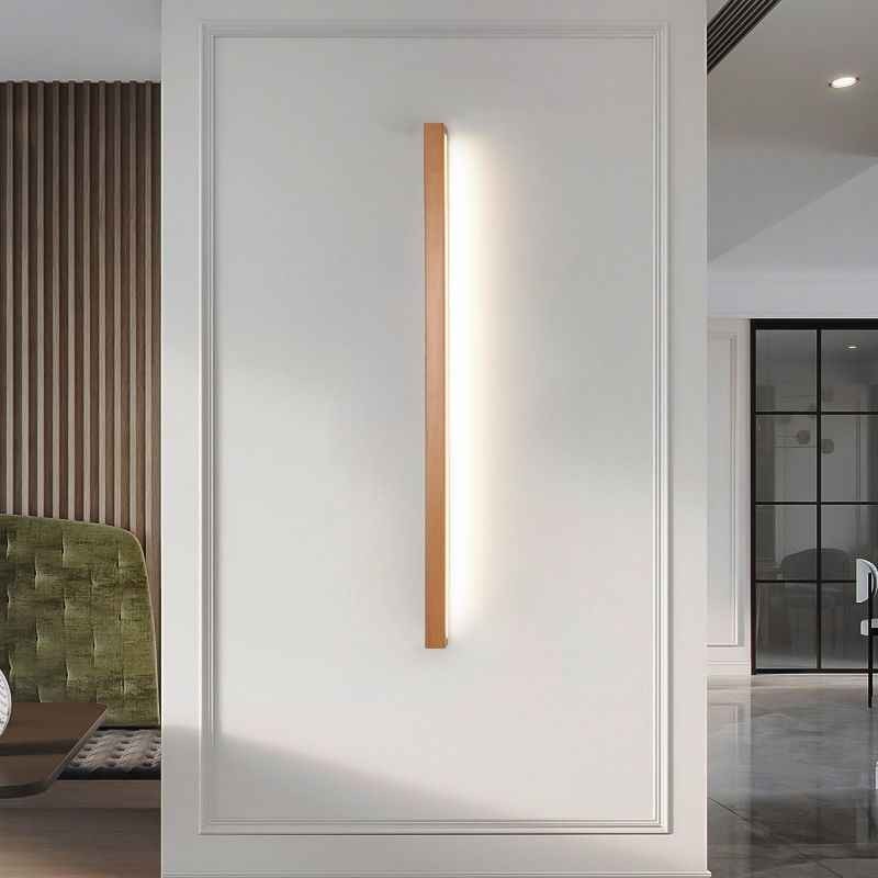 Applique murale linéaire Dimoree en bois naturel avec éclairage LED chaud installée sur un mur blanc mouluré