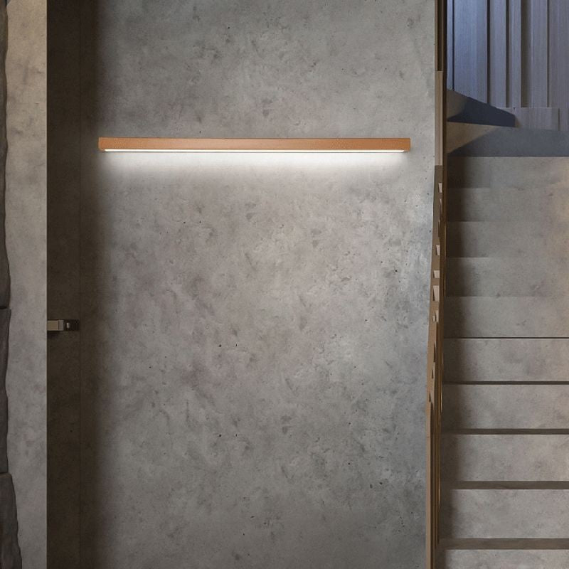 Applique murale linéaire Dimoree en bois naturel avec éclairage LED chaud installée sur un mur en béton gris