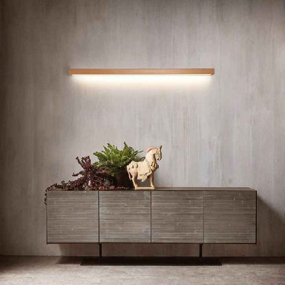 Applique murale Dimoree linéaire en bois naturel avec éclairage LED chaud installée au-dessus d'un buffet moderne