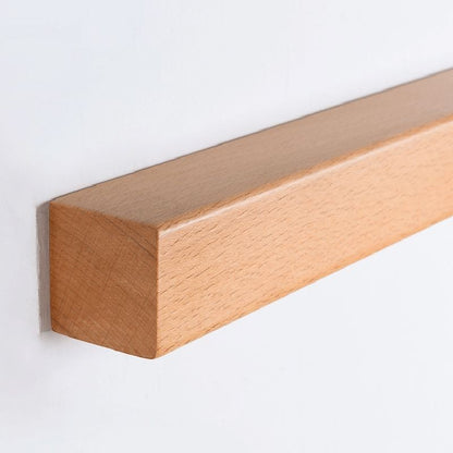 Applique murale Dimoree linéaire minimaliste en bois naturel clair fixée sur un mur blanc