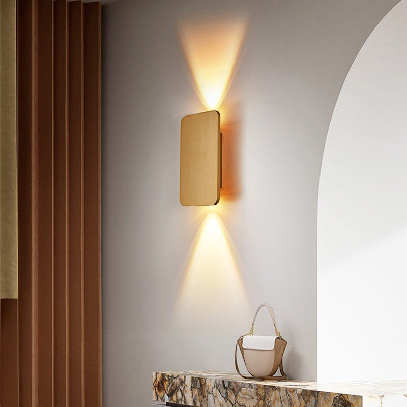 Applique murale Dimoree carrée en métal doré avec éclairage LED bidirectionnel sur un mur intérieur moderne