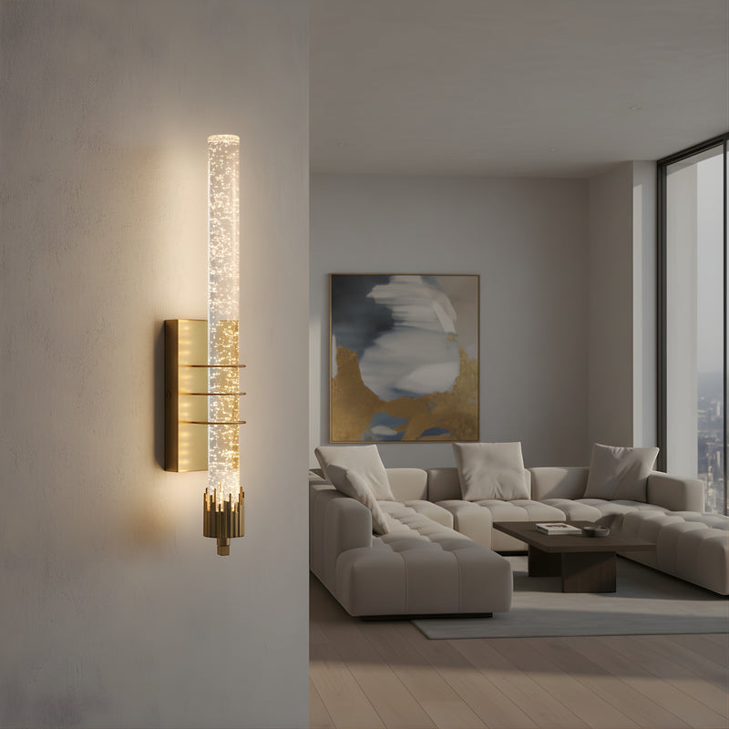 Applique murale Dimoree moderne en cristal cylindrique avec détails dorés diffusant une lumière chaude dans un salon