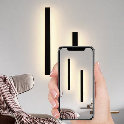 Applique murale Dimoree minimaliste noire en métal avec éclairage LED diffusant une lumière douce sur un mur intérieur