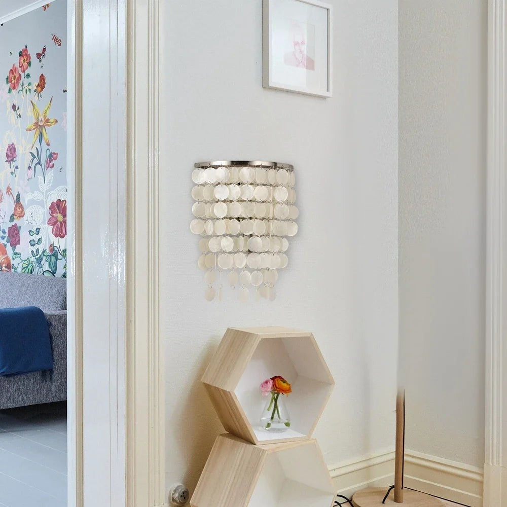 Applique murale Dimoree en nacre blanche avec pampilles circulaires suspendues dans un salon moderne