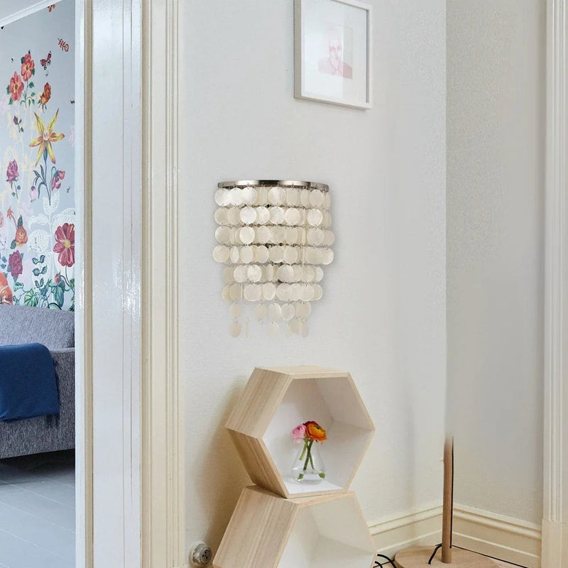 Applique murale Dimoree en nacre blanche avec pampilles circulaires suspendues dans un salon moderne