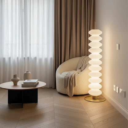 Lampadaire design Dimoree en acrylique blanc empilé diffusant une lumière douce dans un salon contemporain