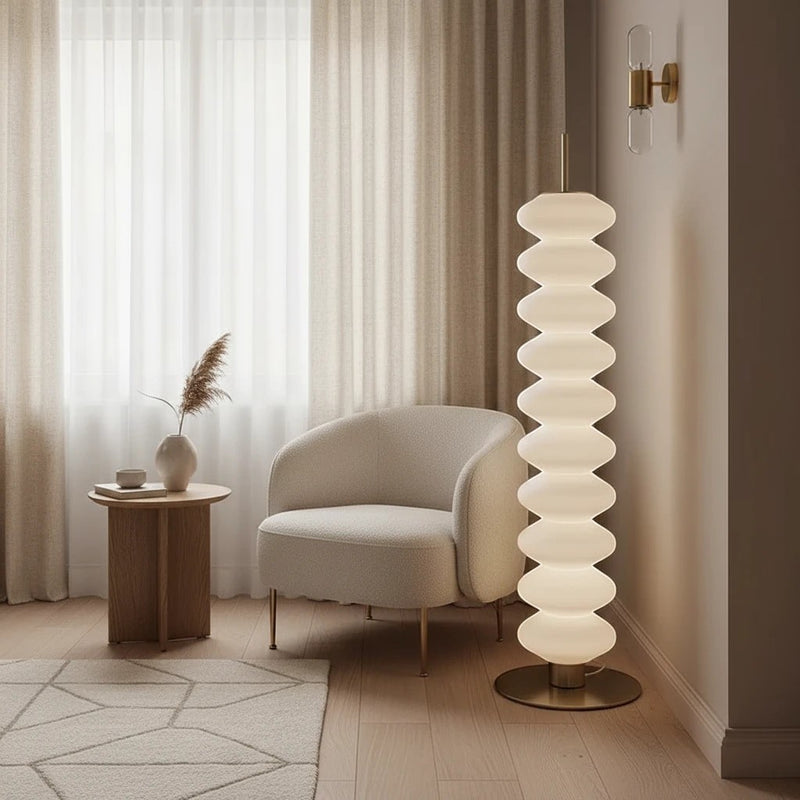 Lampadaire design Dimoree en acrylique blanc à structure empilée, diffusant une lumière douce dans un salon moderne.