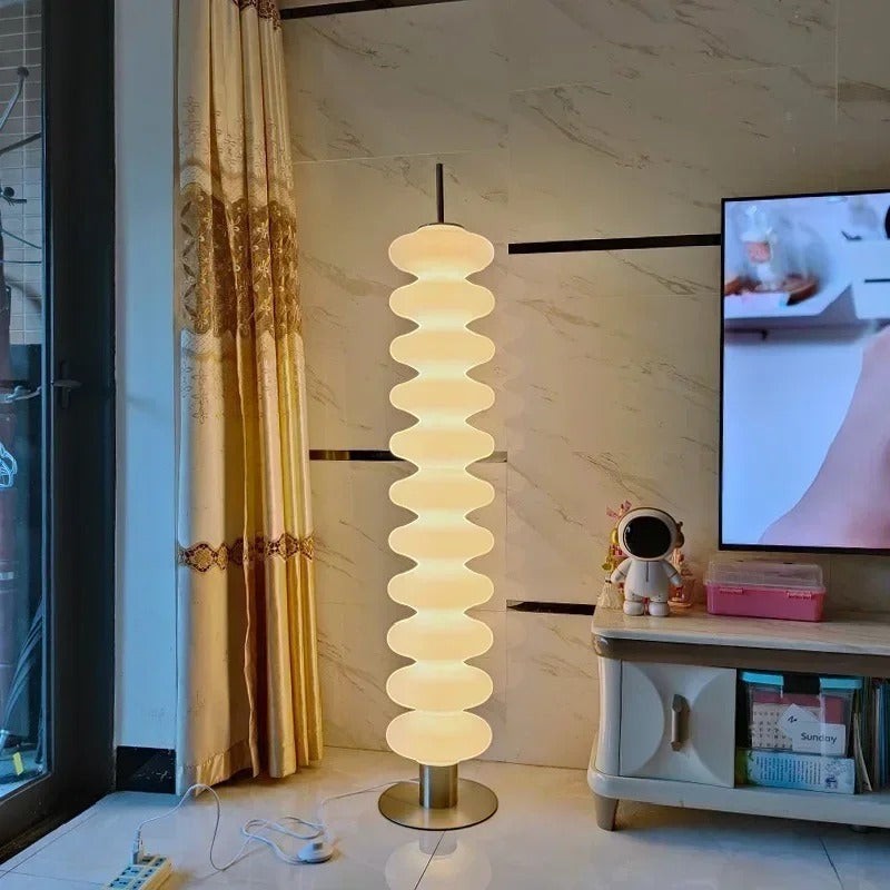 Lampadaire design Dimoree en acrylique blanc avec structure empilée pour une lumière douce dans un salon moderne