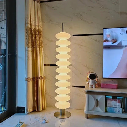 Lampadaire design Dimoree en acrylique blanc avec structure empilée pour une lumière douce dans un salon moderne
