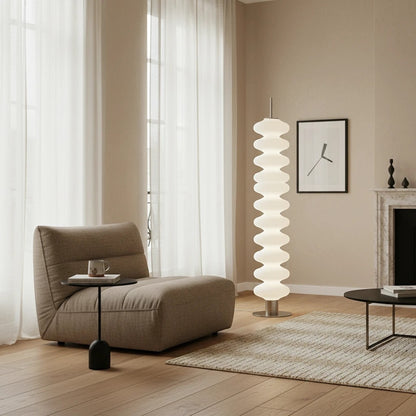 Lampadaire design Dimoree en acrylique blanc à structure empilée dans un salon contemporain aux tons neutres