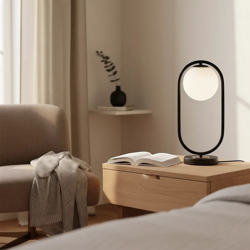 Lampe à poser LED Dimoree au design moderne avec globe en verre blanc et structure noire sur une table de chevet en bois
