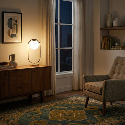 Lampe à poser LED Dimoree au design moderne avec globe en verre blanc et structure métallique sur un buffet en bois