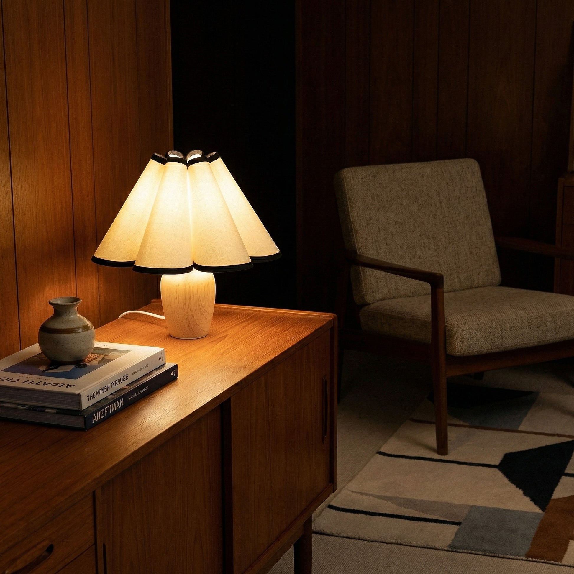 Lampe de table Dimoree avec abat-jour plissé beige et base en bois clair sur un buffet en bois dans un salon cosy