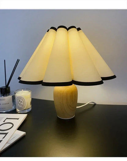 Lampe de table Dimoree avec base en bois clair et abat-jour plissé crème à bordures noires pour une ambiance cosy