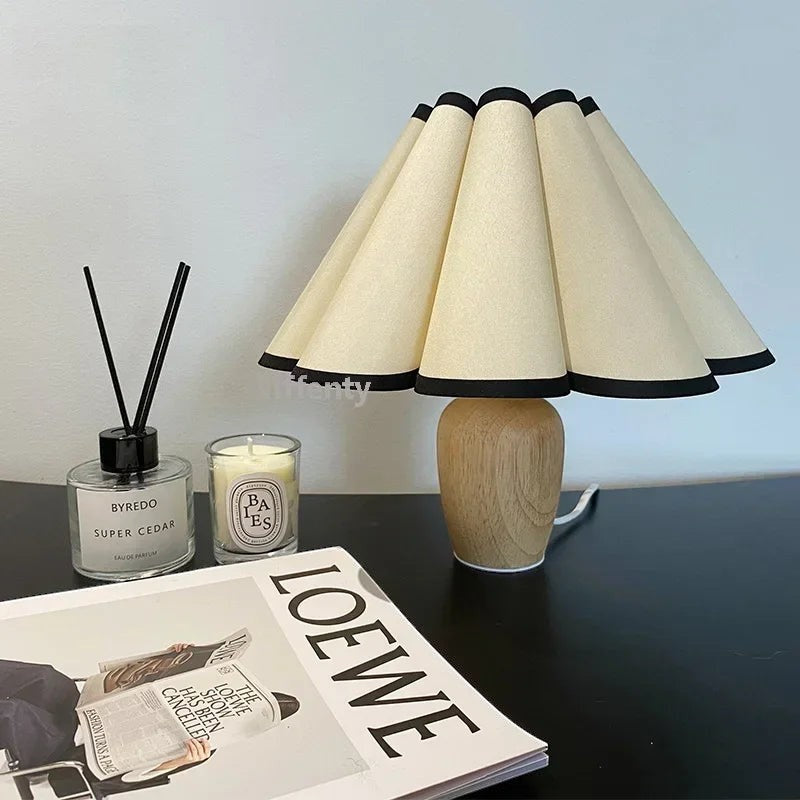 Lampe de table Dimoree avec base en bois clair et abat-jour plissé beige à bordure noire pour une ambiance cosy