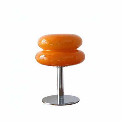 Lampe de table Dimoree en verre soufflé orange avec pied en métal chromé au design rétro-chic organique.