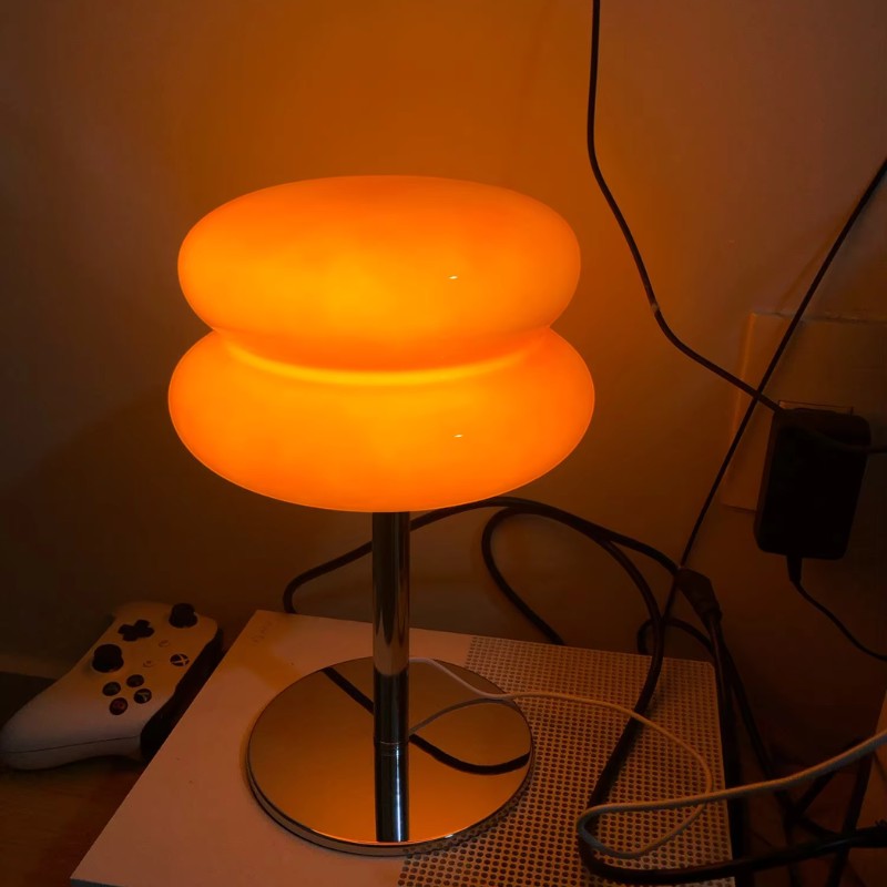 Lampe de table Dimoree en verre soufflé orange avec base en métal chromé au design rétro-chic et lumière chaleureuse.