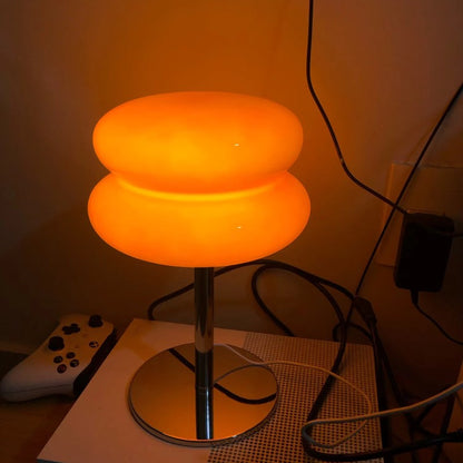 Lampe de table Dimoree en verre soufflé orange avec base en métal chromé au design rétro-chic et lumière chaleureuse.