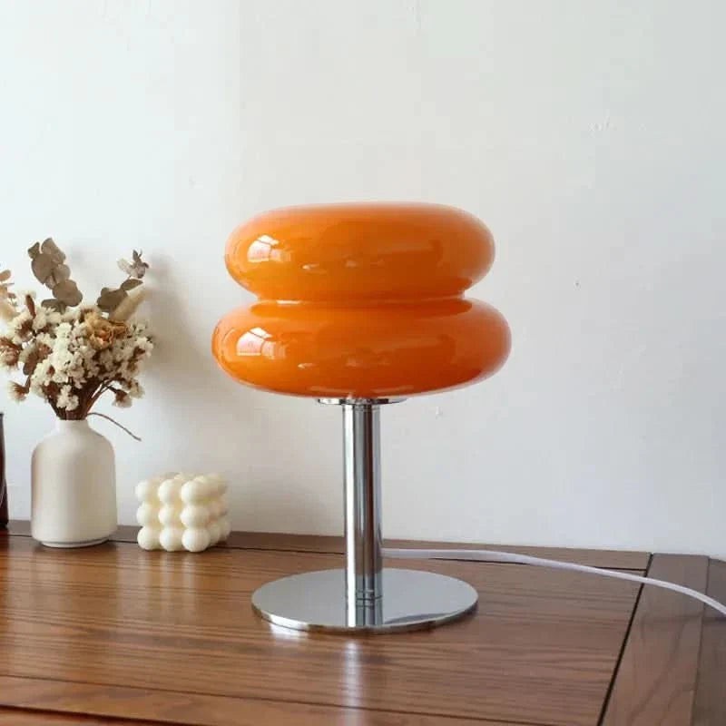 Lampe de table Dimoree en verre soufflé orange avec pied en métal chromé au design rétro-chic organique.