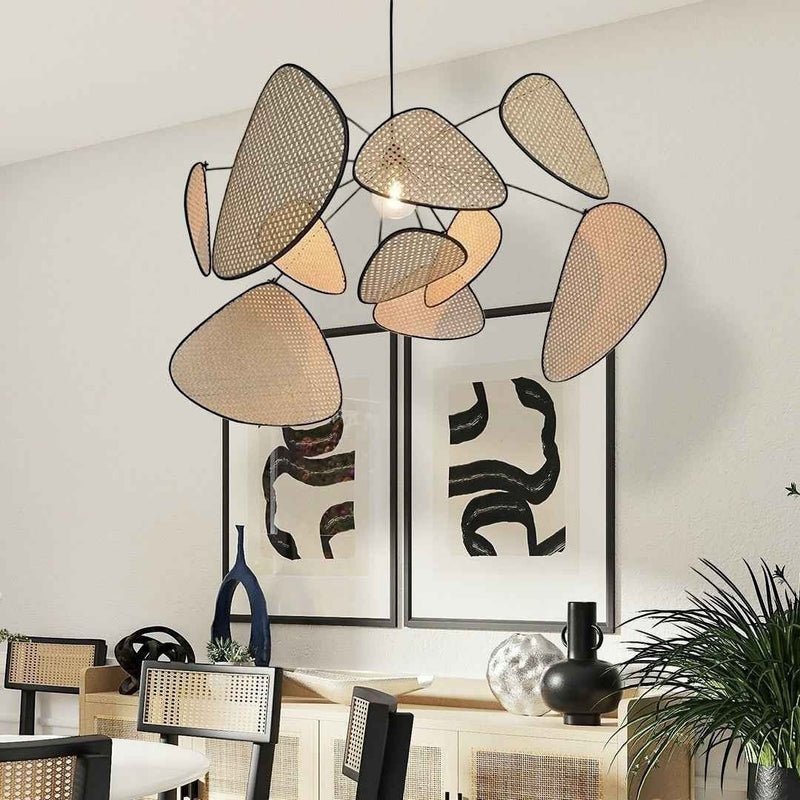 Lustre bohème Dimoree en bambou tressé avec structure organique suspendu au-dessus d'une salle à manger moderne.