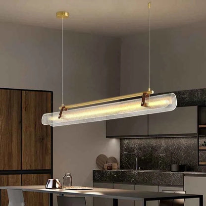 Lustre LED Dimoree minimaliste en verre strié et métal doré suspendu au-dessus d'une table de salle à manger moderne