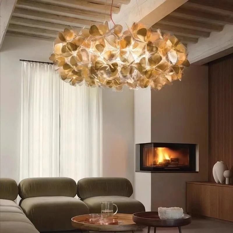 Lustre moderne Dimoree en cristal taillé doré suspendu au-dessus d'un salon contemporain avec cheminée