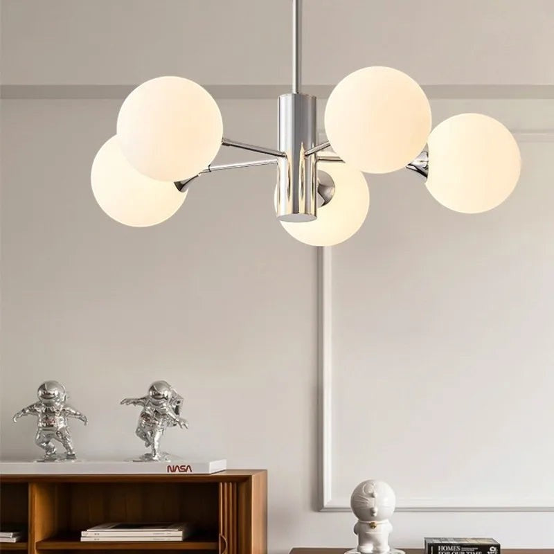 Lustre moderne Dimoree à structure en métal chromé et globes en verre dépoli pour un éclairage design et chaleureux.