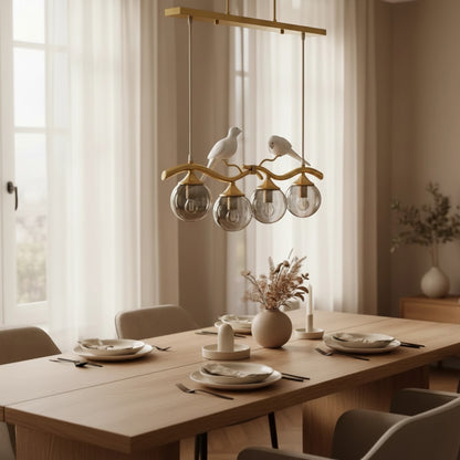 Lustre moderne Dimoree en métal doré avec globes en verre et figurines d'oiseaux au-dessus d'une table de salle à manger