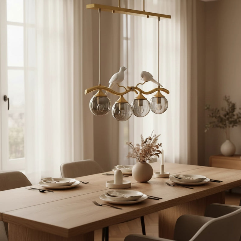 Lustre moderne Dimoree en métal doré avec globes en verre et figurines d'oiseaux au-dessus d'une table de salle à manger