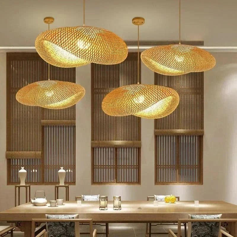 Quatre lustres en rotin Dimoree suspendus au-dessus d'une table en bois dans une salle à manger au style naturel.