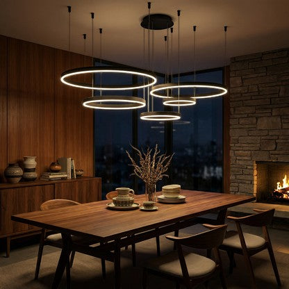 Lustre suspendu Dimoree à anneaux LED modernes au-dessus d'une table en bois dans une salle à manger chaleureuse