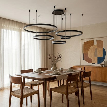 Lustre suspendu Dimoree à anneaux noirs modernes au-dessus d'une table à manger en bois dans un salon élégant