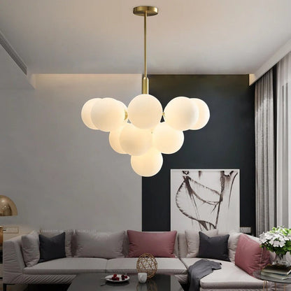 Lustre design Dimoree en verre soufflé blanc avec structure dorée suspendu dans un salon moderne