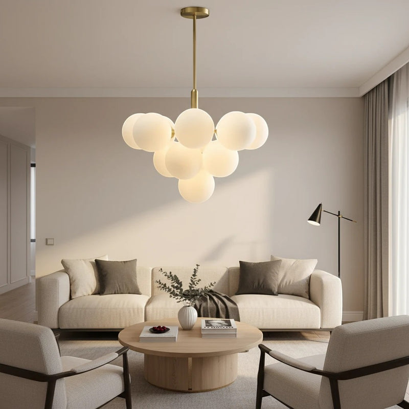 Lustre Dimoree design avec globes en verre soufflé blanc et structure dorée suspendu au-dessus d'un salon moderne.