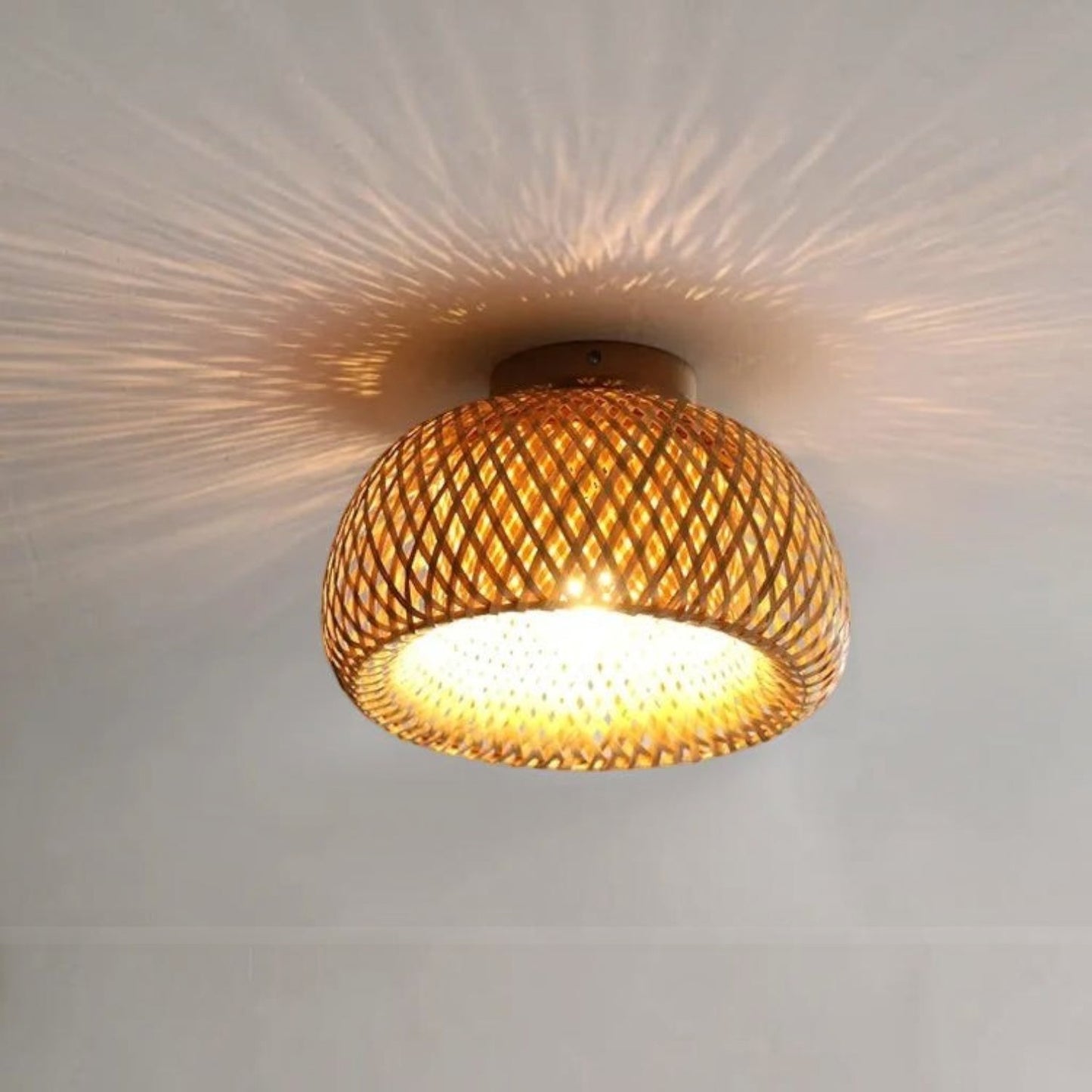 Plafonnier Dimoree en bambou tissé rétro diffusant une lumière chaleureuse avec des motifs d'ombres sur le plafond