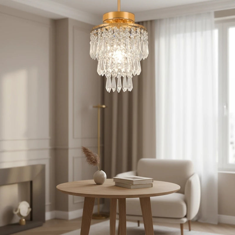 Plafonnier Dimoree en cristal doré et acier inoxydable suspendu au-dessus d'une table ronde dans un salon moderne