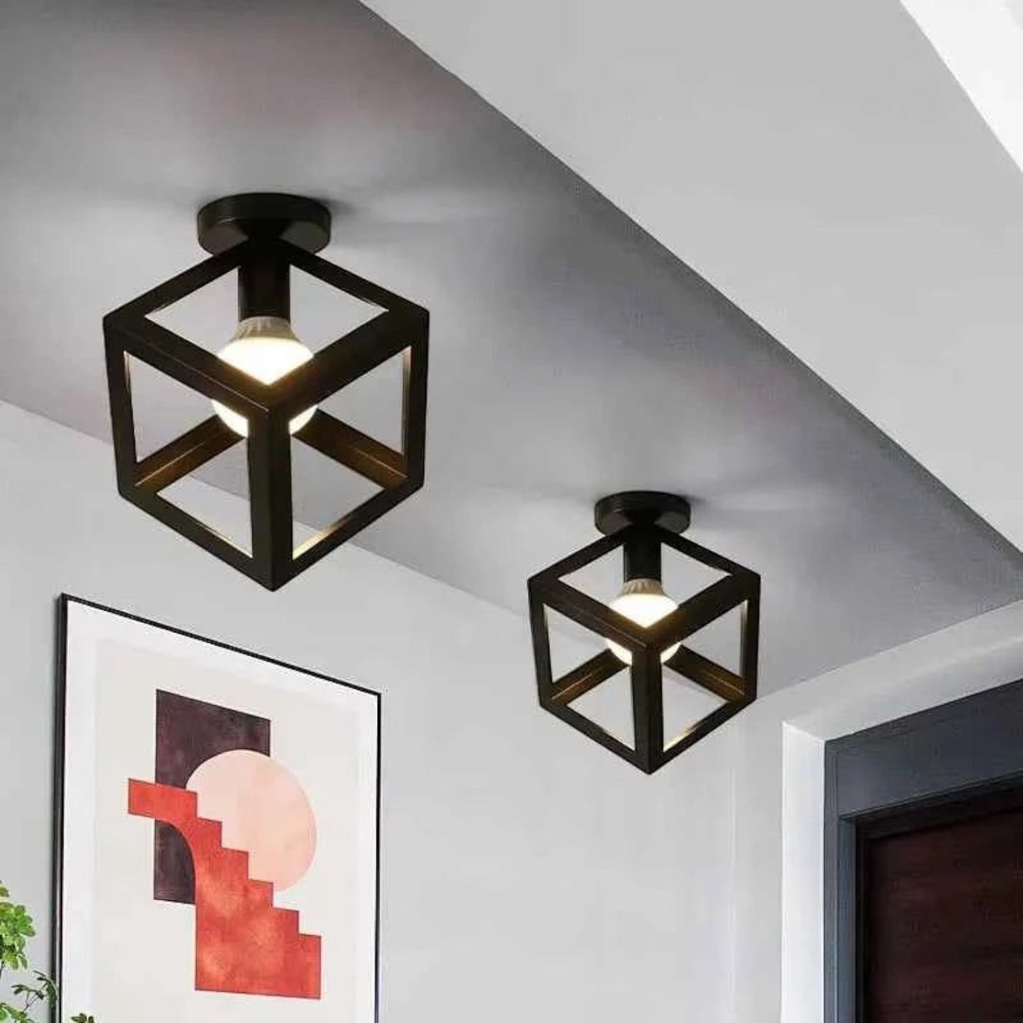 Deux plafonniers Dimoree noirs en forme de cube métallique style industriel installés au plafond d'un intérieur moderne