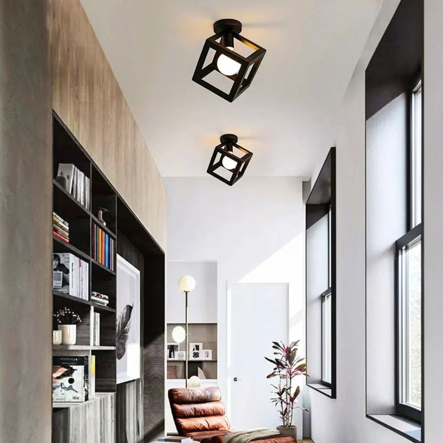 Plafonnier industriel vintage Dimoree en métal noir forme cube installé dans un couloir moderne