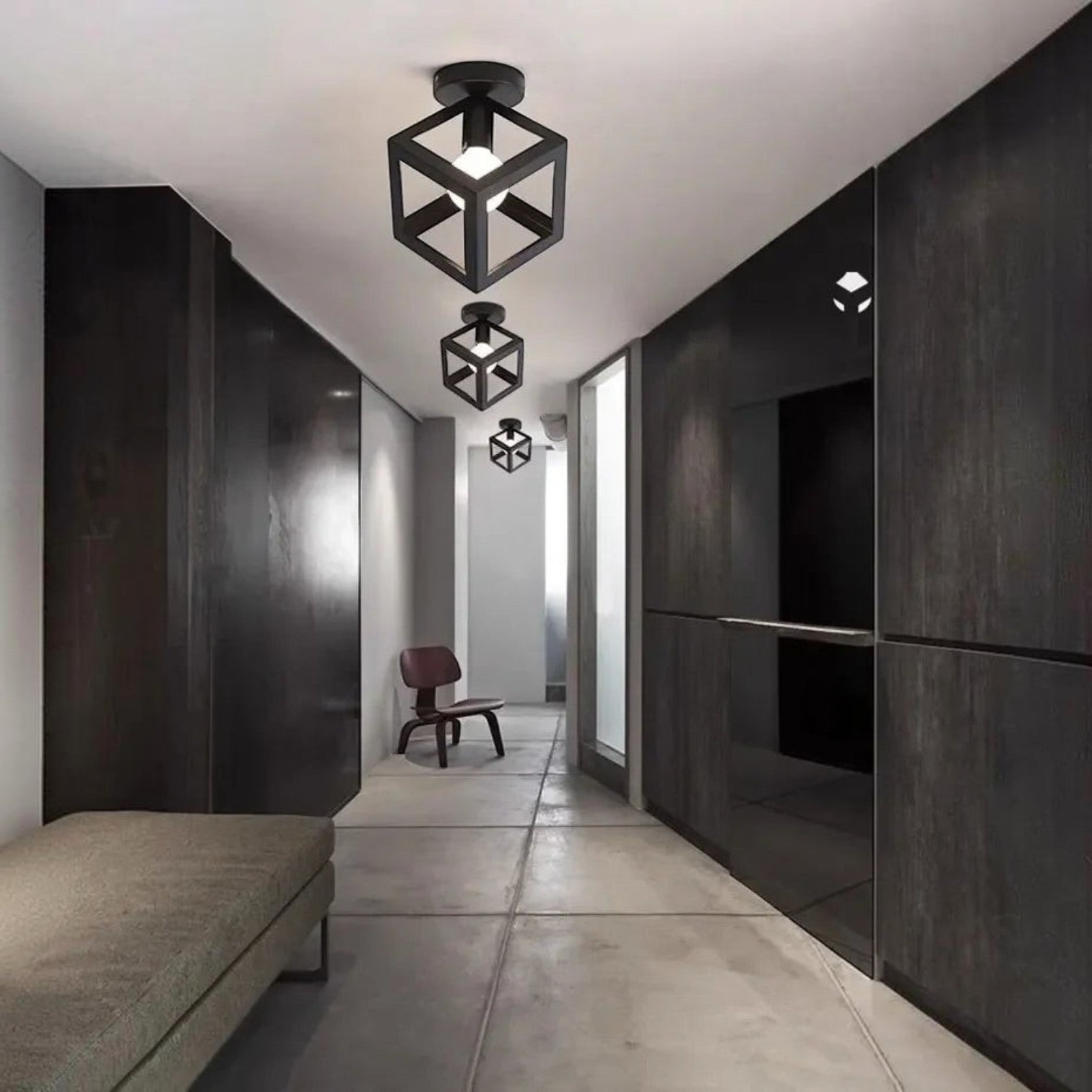 Plafonnier industriel Dimoree en métal noir forme cube géométrique installé dans un couloir moderne