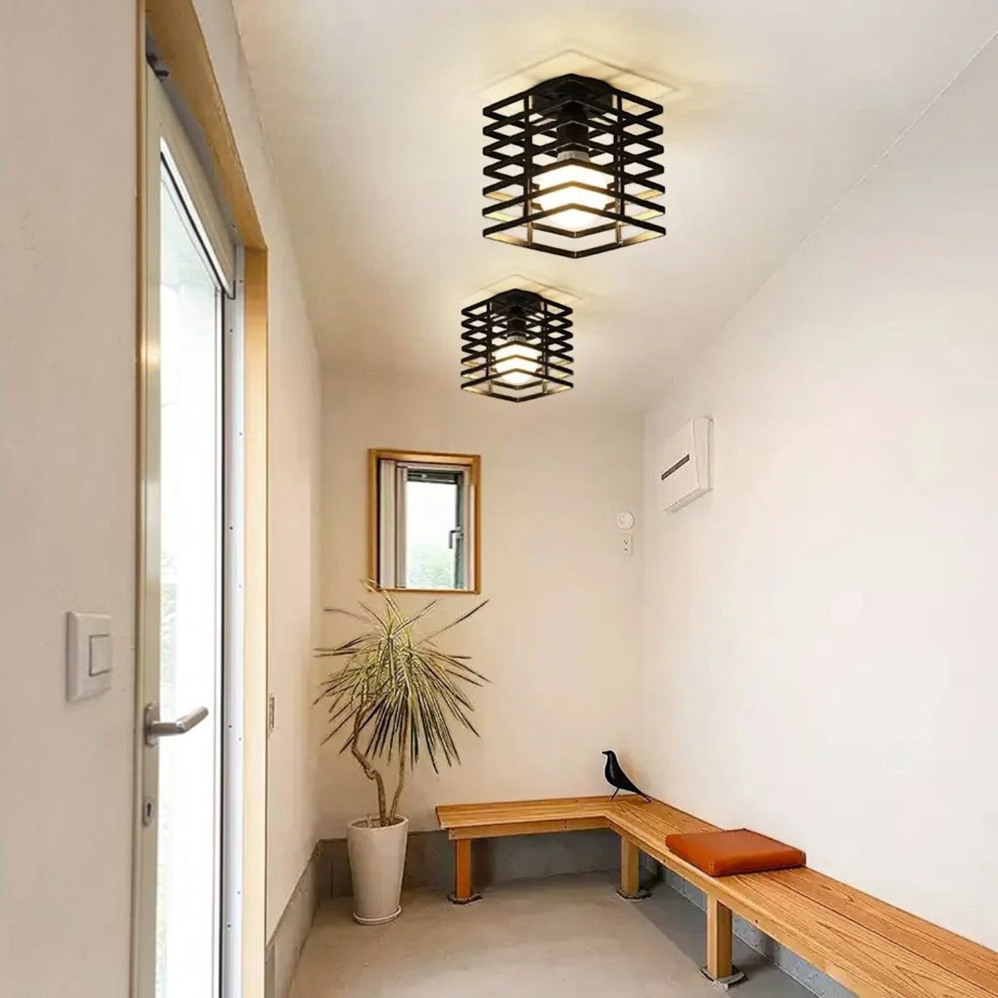 Deux plafonniers Dimoree industriels noirs en métal installés dans une entrée lumineuse avec un banc en bois