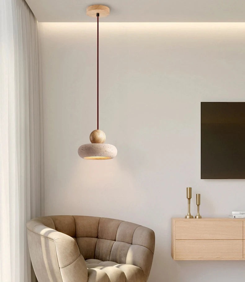 Suspension luminaire Dimoree en bois et pierre au design minimaliste suspendue au-dessus d'un fauteuil beige