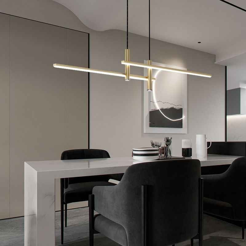 Suspension design Dimoree Prym en métal doré au-dessus d'une table de salle à manger moderne et minimaliste