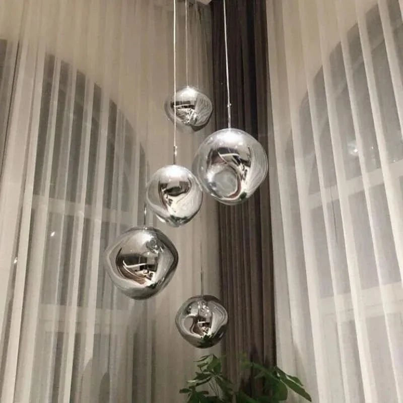 Suspension lumineuse Dimoree en verre soufflé argenté aux formes organiques irrégulières pour un intérieur moderne.