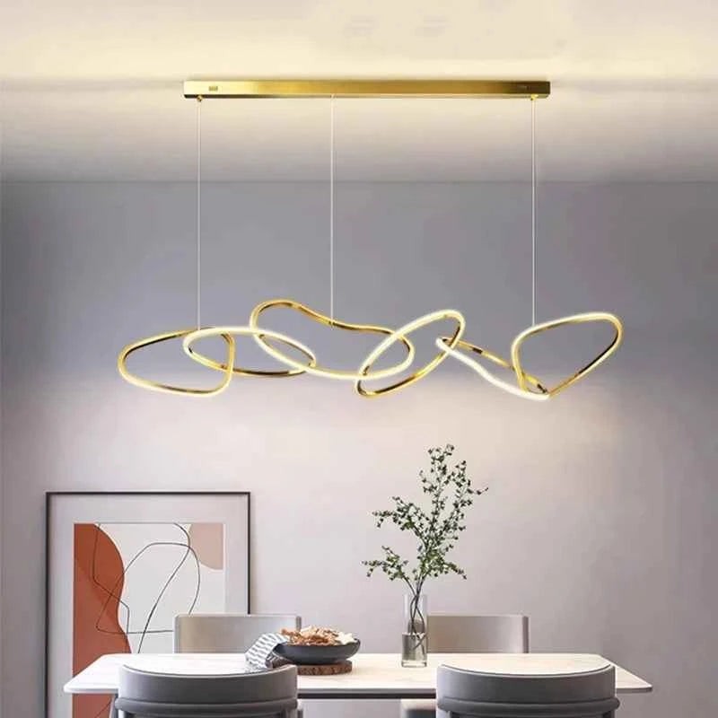 Suspension lumineuse Dimoree moderne en alliage doré avec anneaux entrelacés au-dessus d'une table de salle à manger