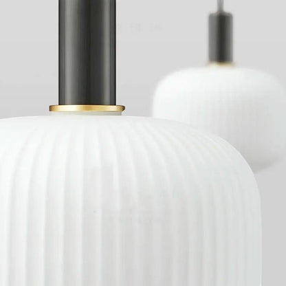 Suspension lumineuse Dimoree en verre dépoli nervuré blanc avec structure en métal noir mat et détails dorés.