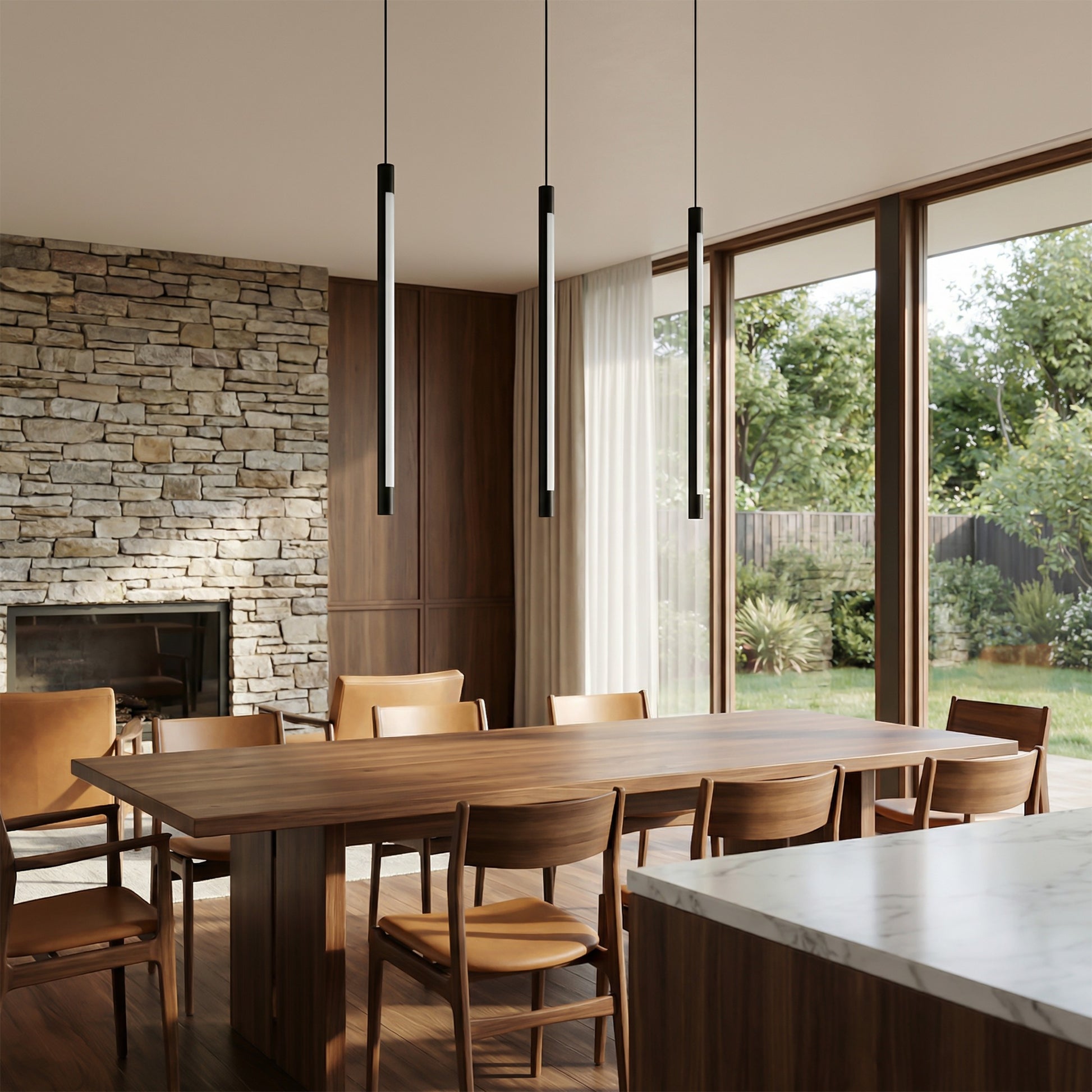 Suspension lumineuse tubulaire noire Dimoree au-dessus d'une table en bois dans un salon moderne avec mur en pierre.