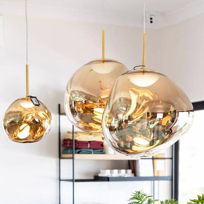 Suspension lumineuse Dimoree en verre soufflé doré aux formes organiques pour un éclairage moderne et chaleureux.
