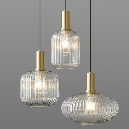 Suspension lumineuse Dimoree en verre nervuré transparent et métal doré brossé pour un éclairage intérieur élégant.