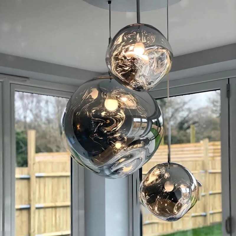 Suspension lumineuse Dimoree en verre soufflé organique avec finition miroir ambrée pour un design moderne et élégant.