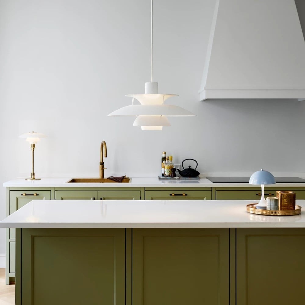 Suspension Dimoree Macaron blanche au design moderne installée au-dessus d'un îlot de cuisine vert
